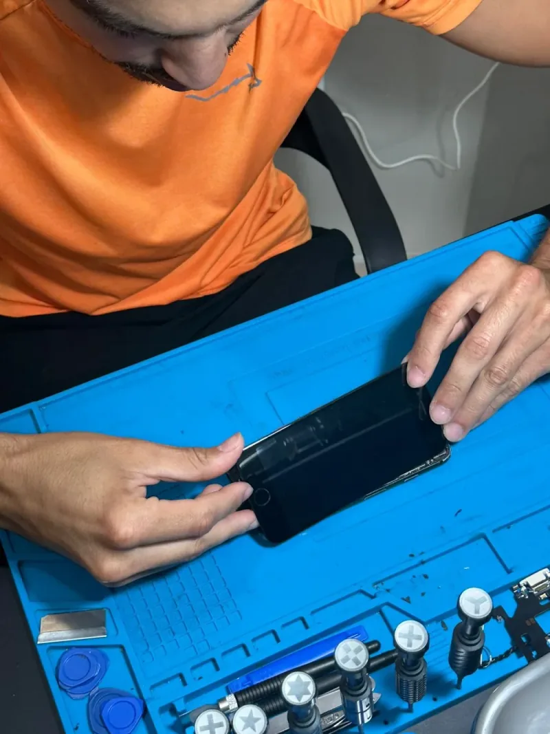 Detalhe do trabalho em um celular aberto sobre a bancada